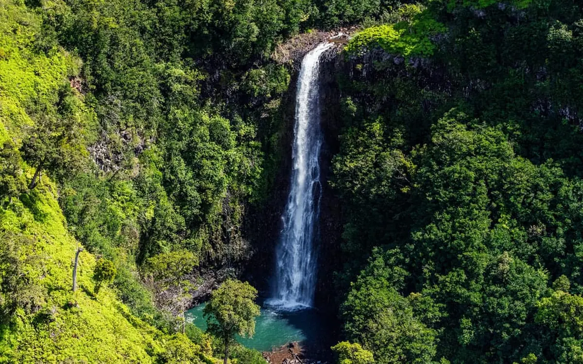 A helicopter banking over the sea cliffs of the Na Pali Coast on Kauai