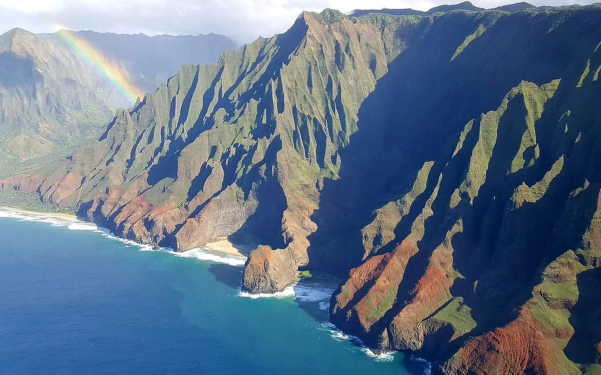 A helicopter banking over the green ridges of Kauai